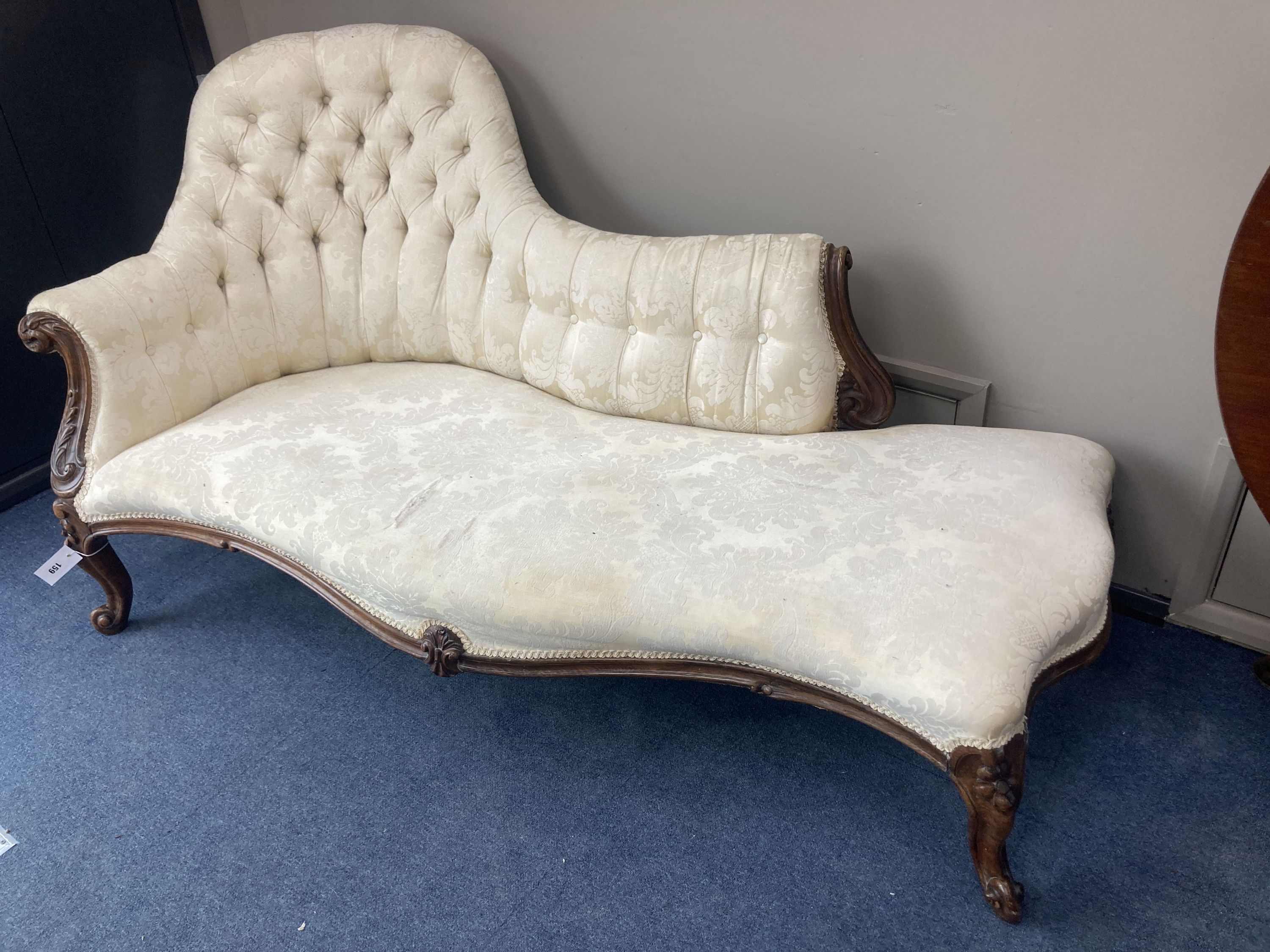 A Victorian carved rosewood chaise longue with button shaped back and serpentine seat raised on cabriole carved legs, length 160cm, dep